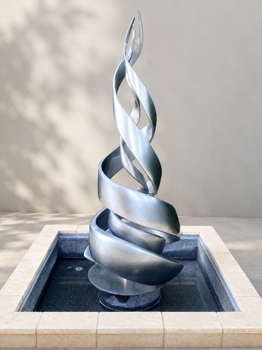 Original silver metal sculpture in a courtyard water feature.