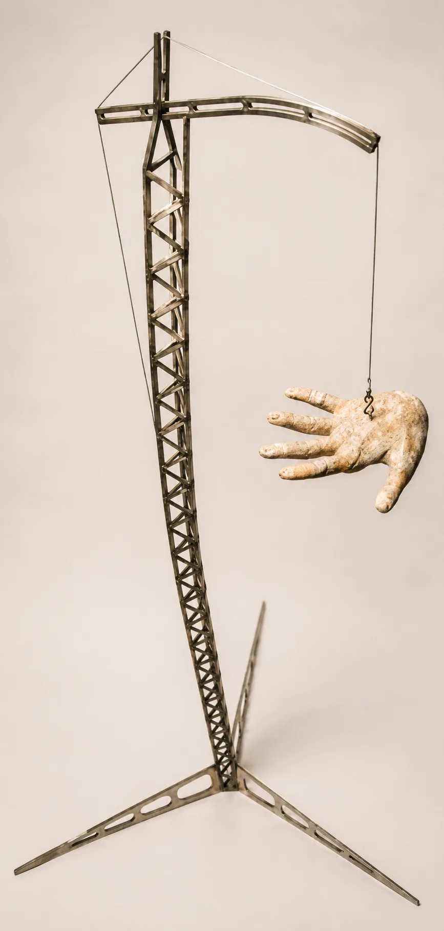 Crane sculpture paired with a suspended hand in an original metal artwork.