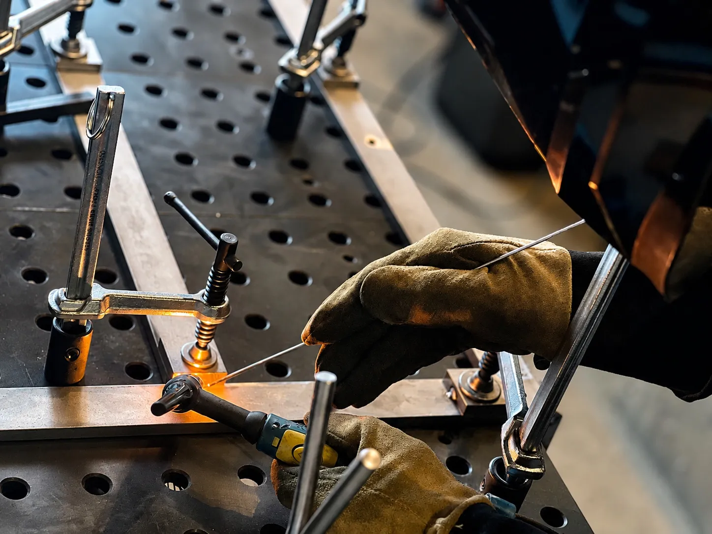 Welding and fabrication process at a metalwork table.